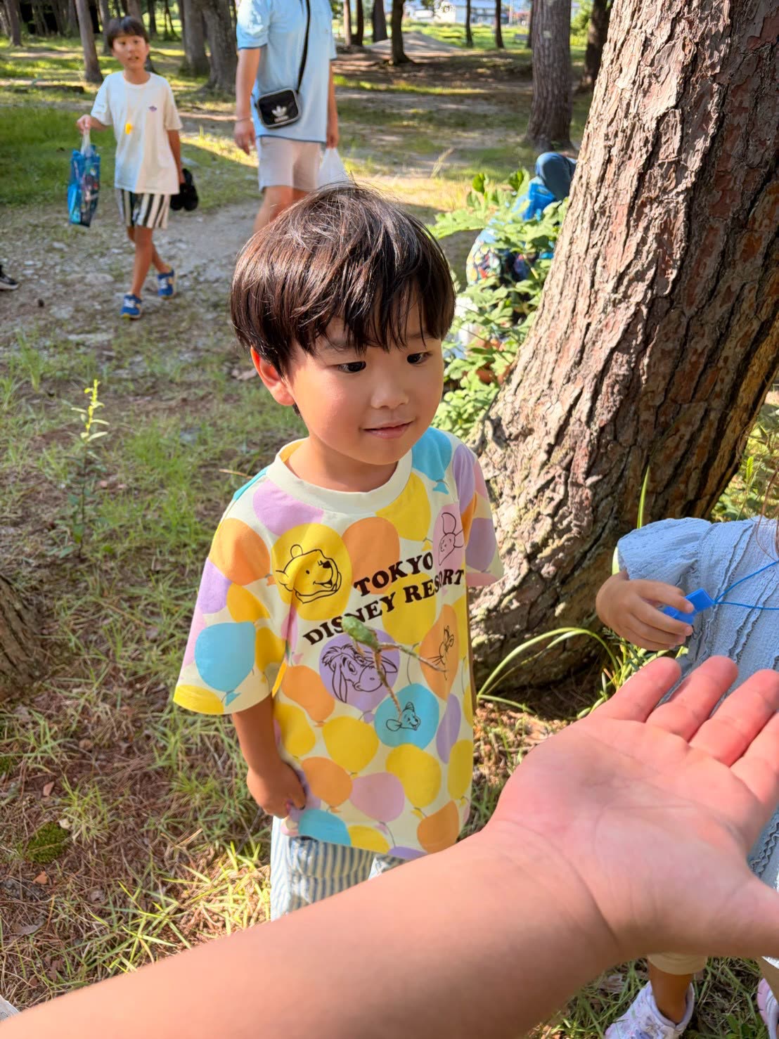 Child holding an insect during a nature moment in Japan