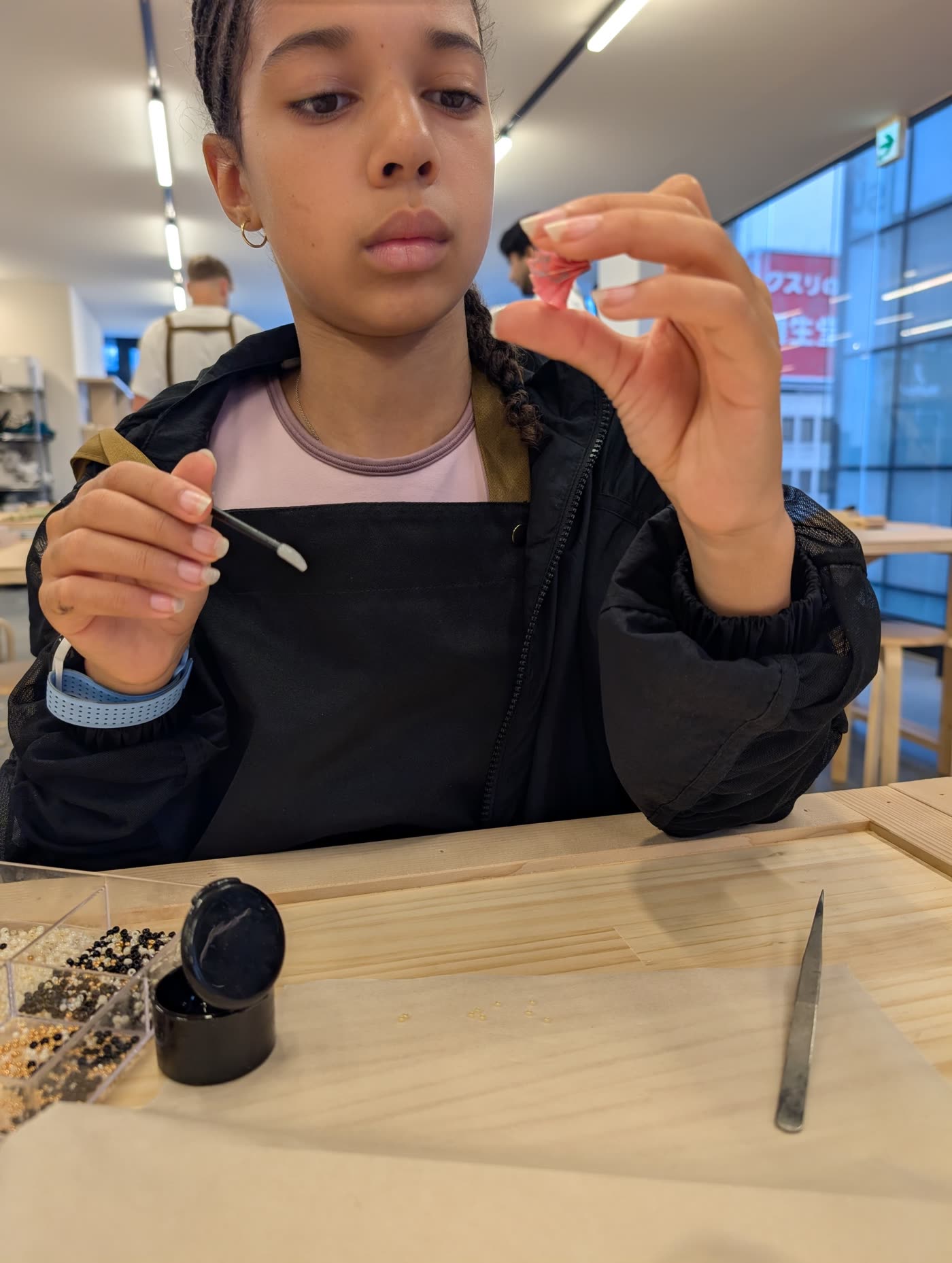 Focused child at a beading workshop in Tokyo